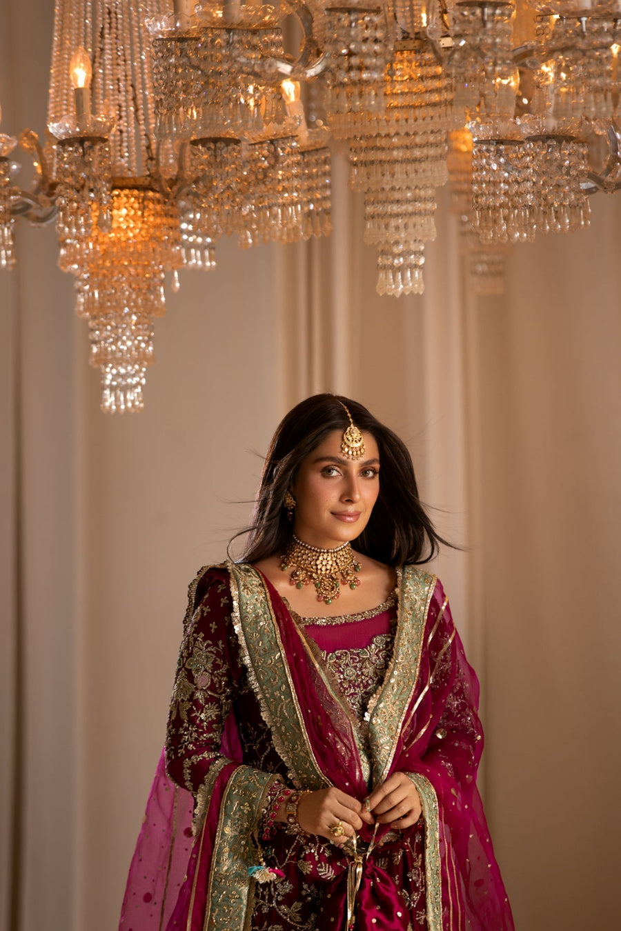 Woman in traditional attire under a chandelier